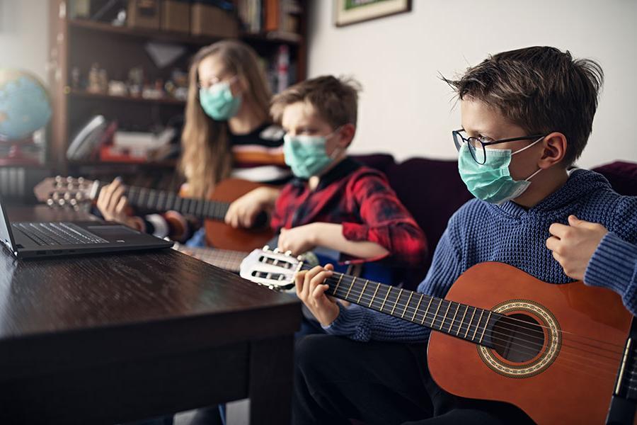 students playing guitar in masks